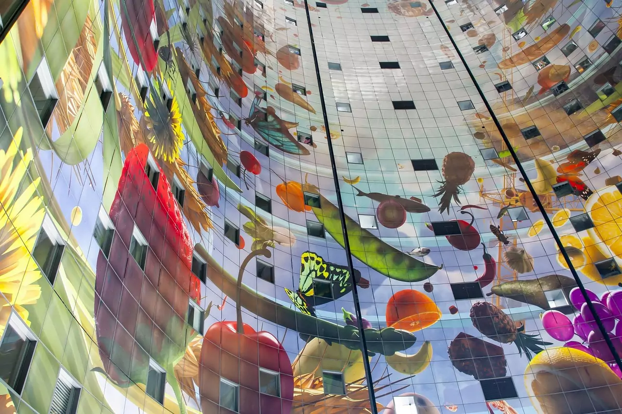 Binnenkant van de Markthal in Rotterdam, met het kleurrijke kunstwerk op het plafond dat de ruimte siert.